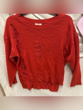 Long sleeve red ripped style sweater. Adult Size medium .